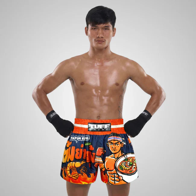 Man wearing colourful boxing shorts with a TUFF logo on a gray background